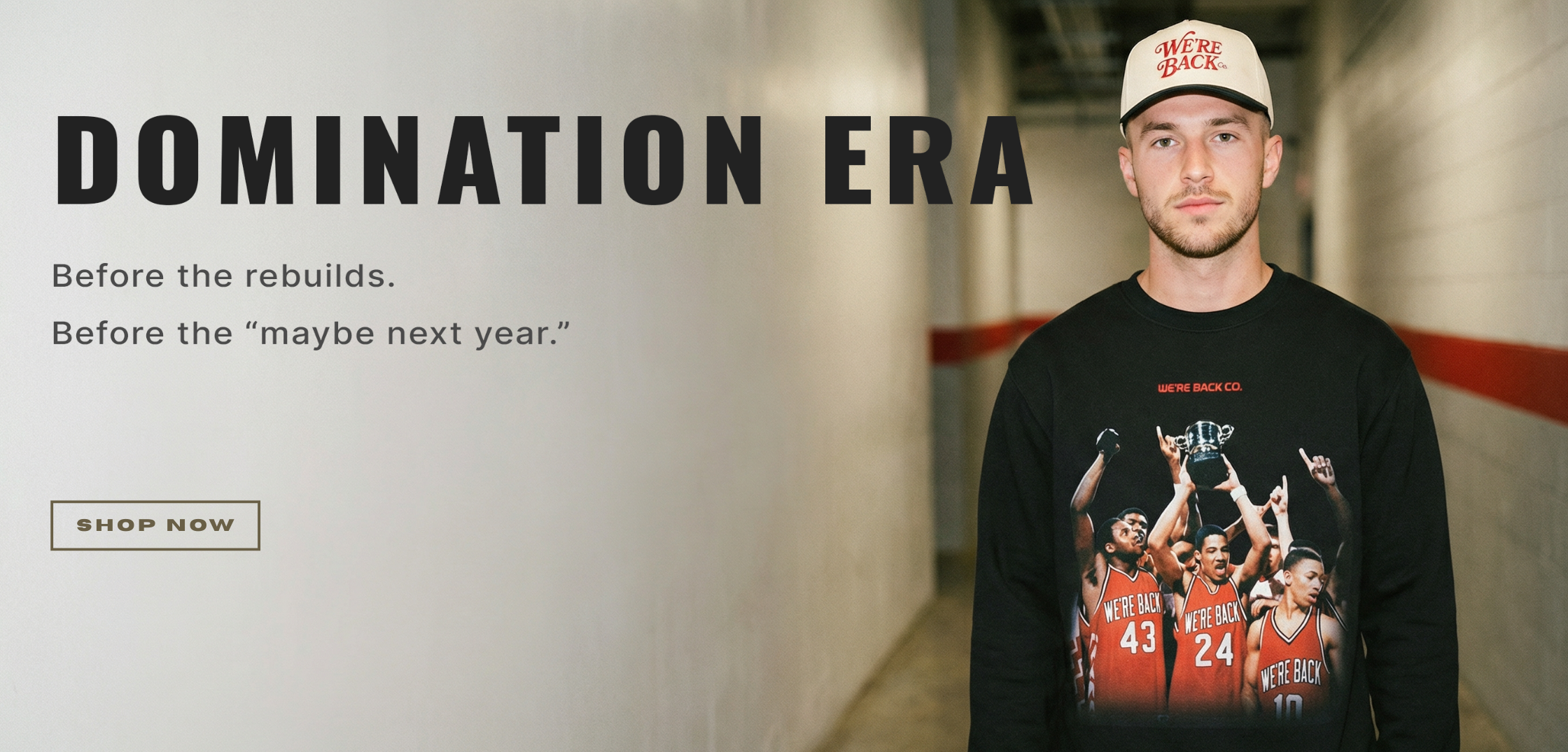 Person wearing a black sweatshirt with a sports team graphic, standing in a hallway with promotional text.