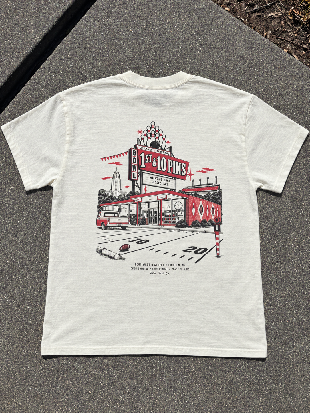 Original sample photo: cream tee back with 1ST & 10 PINS fictional Lincoln bowling alley artwork