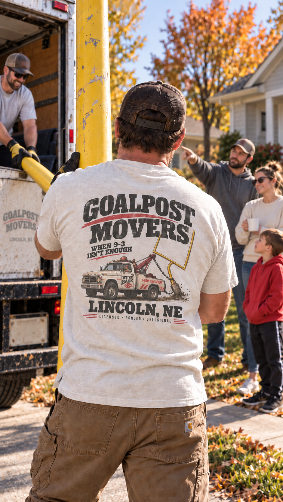 A mover wearing the Goalpost Movers tee delivers a yellow goalpost to a family's driveway.