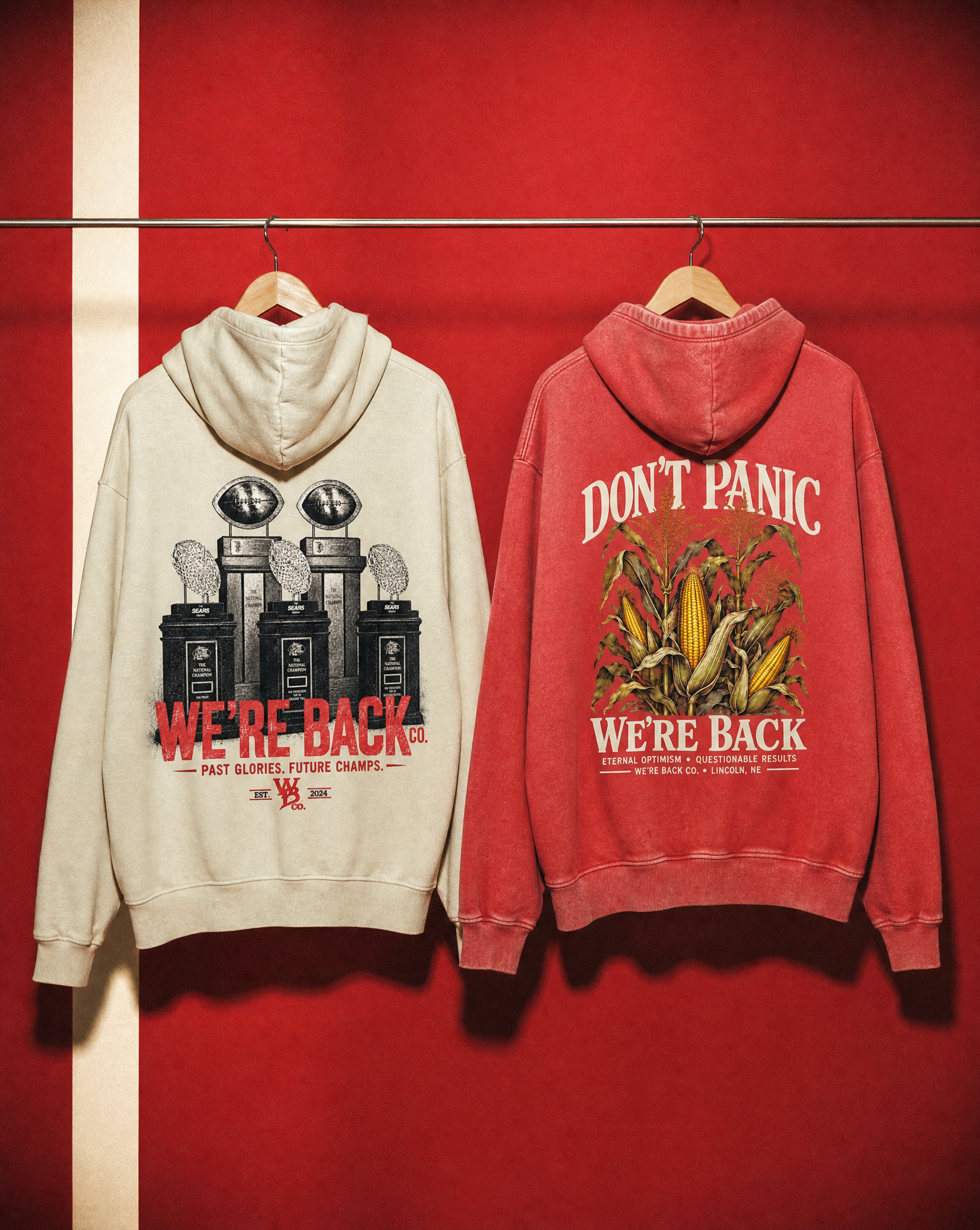 Backs of the natural Trophy Hoodie and vintage red Don't Panic Hoodie hanging side by side.